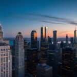 Uma vista panorâmica do horizonte de uma cidade ao anoitecer, com arranha-céus altos se elevando em direção ao céu, iluminados pelo brilho quente dos postes de luz e das luzes da cidade.